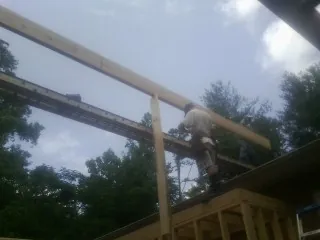 Carpenter setting a ridge beam over a new addition frame — Ice Dam Removal by Roofing Brothers in Chardon