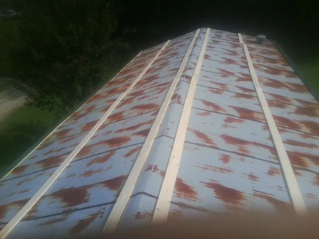 Rusted metal roof panels with new wood purlins before replacement — Storm Damage Roof Repair in Chardon by Roofing Brothers