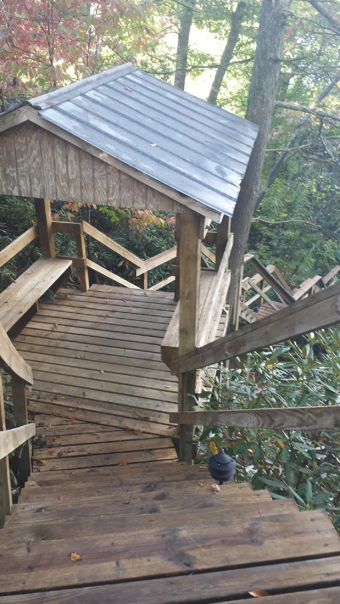 Metal roofed shelter over wooden steps on a wooded walkway — Skylight Repair & Installation work by our crew in Chardon