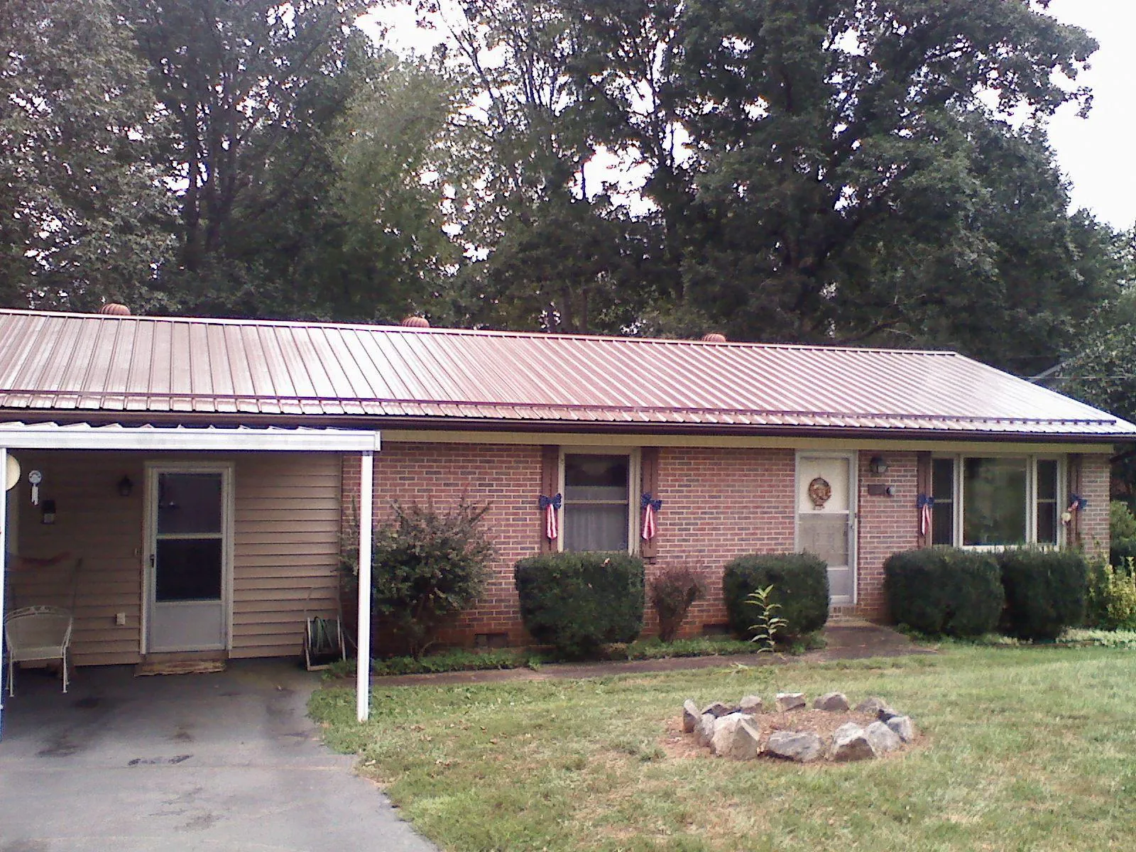 Bronze metal roof and carport on a brick ranch home — Roof Repair work by our crew in Chardon