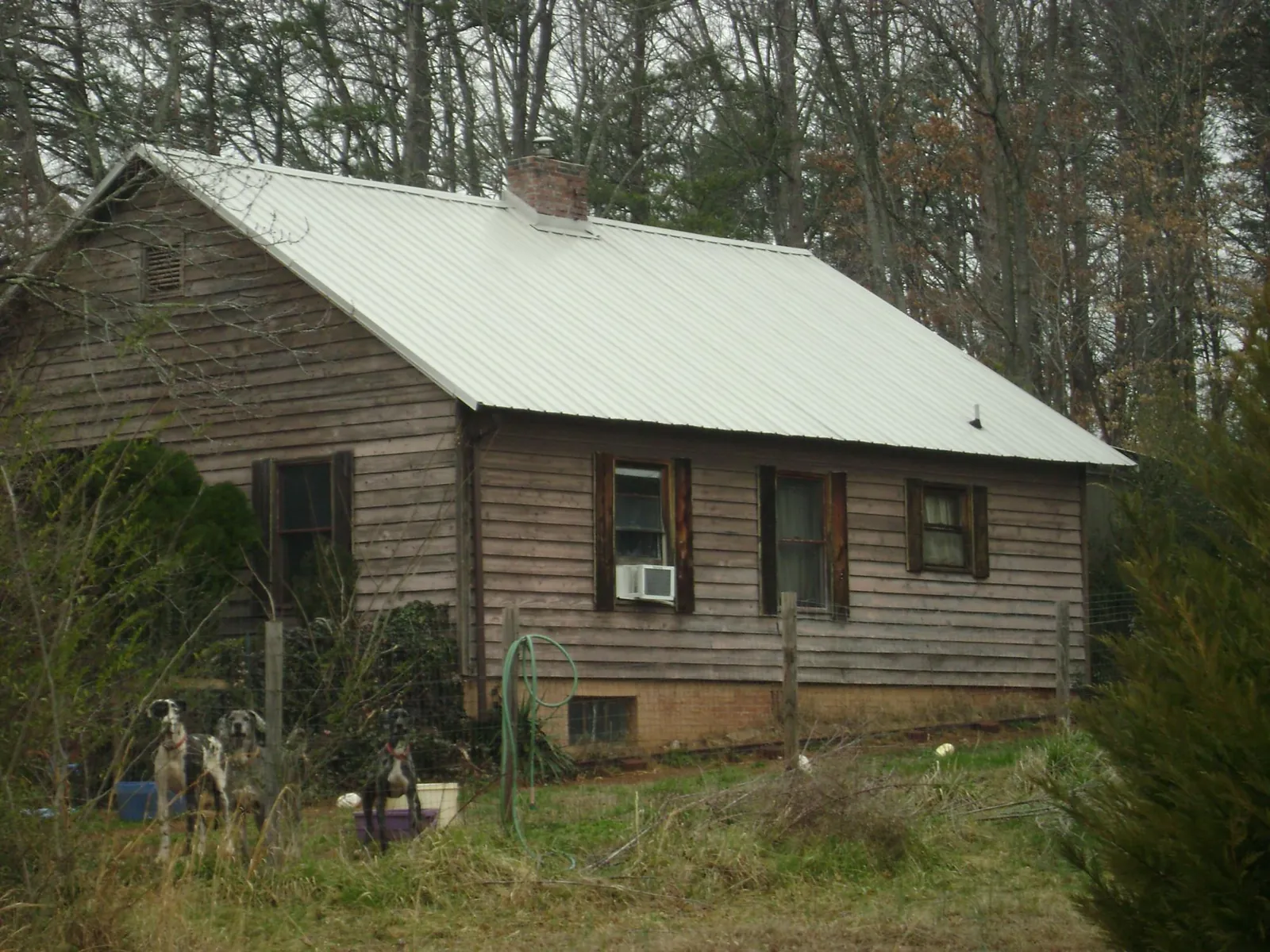 White metal roof on an old wood sided farmhouse, from a Metal Roof Installation job in Chardon